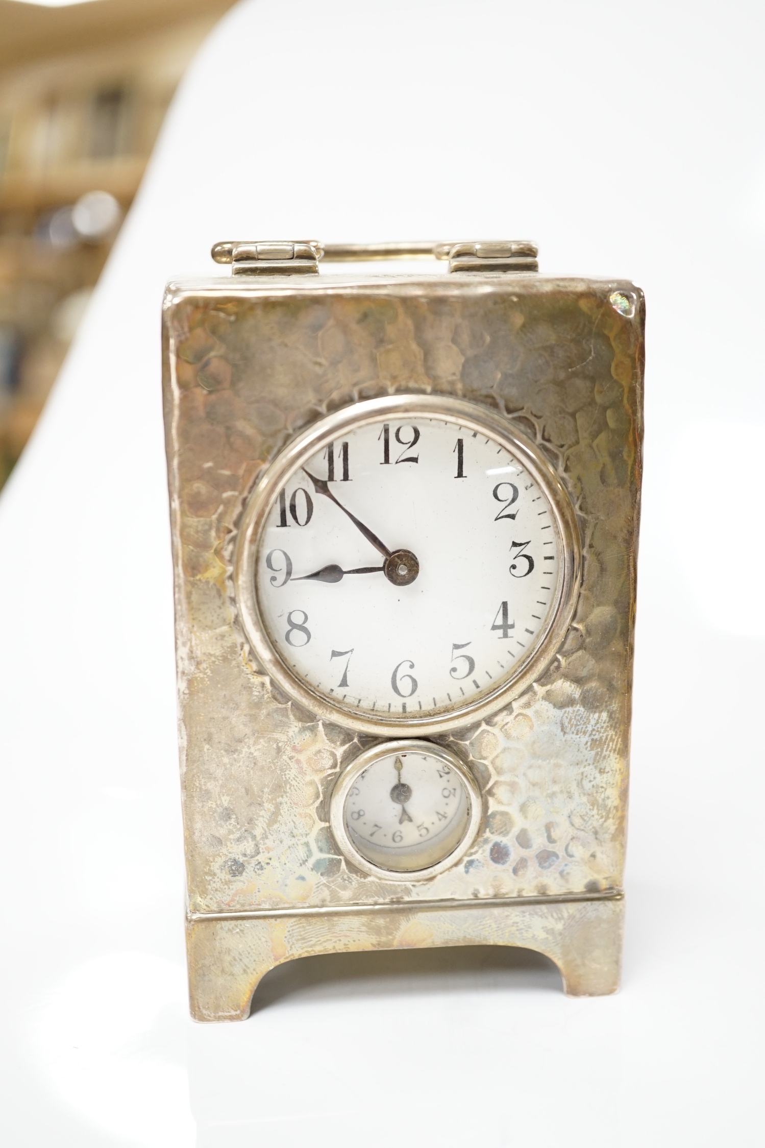 An Edwardian planished silver alarm carriage timepiece, Arthur Baume & Co, London, 1905, height 11cm.